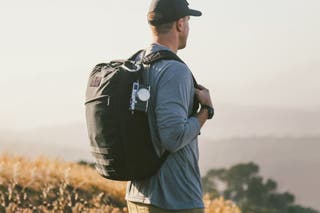 A person in an outdoor environment wearing one of our picks for best buy it for life backpack with a minimalist look, the GoRuck GR1.