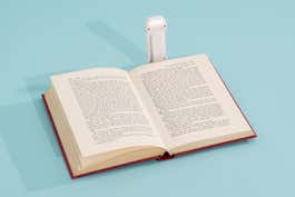 An open book with the Glocusent Bookmark Style Reading Light attached