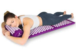 Woman lying on the ProsourceFit Acupressure Mat and Pillow Set 