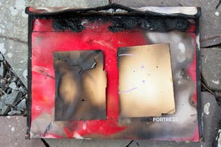 burnt pieces of index cards on top of fireproof envelopes