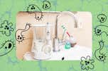 Squiggly drawings of bacteria floating over a photo of our pick for an effective and easy to clean water flosser, the Waterpik Aquarius Professional.