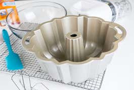 Our top pick bundt pan, the Nordic Ware Platinum Collection Original, resting on a cooling tray surrounded by baking gear.