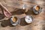 Two coffee cups, creamer, and sugar on a wooden table.