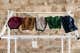 Five cloth face masks drying on a drying rack after being cleaned.