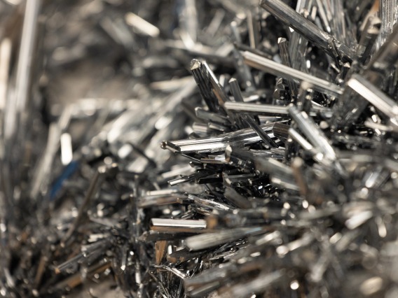 a detailed close-up of silver, metallic stibnite crystals