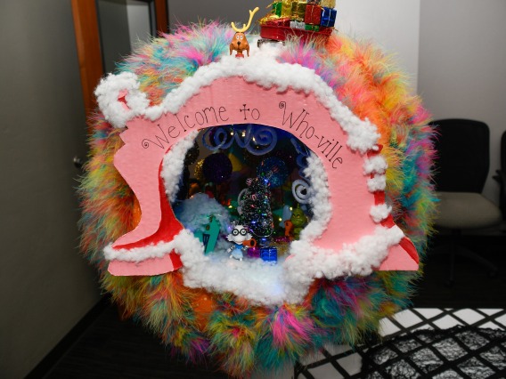 A large, hollow pumpkin is covered in colorful decorations with a pink banner that says "Welcome to Who-Ville." (Logan Burtch-Buus / University Communications)