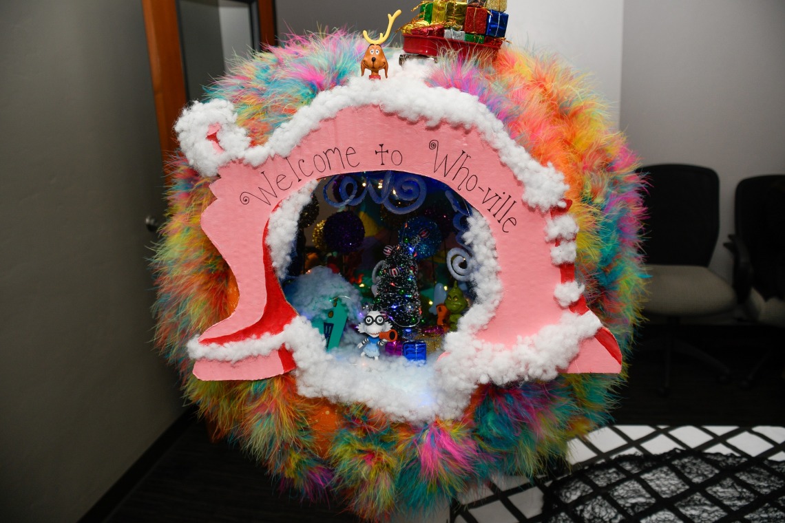 A large, hollow pumpkin is covered in colorful decorations with a pink banner that says "Welcome to Who-Ville." (Logan Burtch-Buus / University Communications)