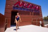 A woman in a blue and redcompetitive swimwear at the top of a diving platform. Above her are the words "Arizona Swimming & Diving"