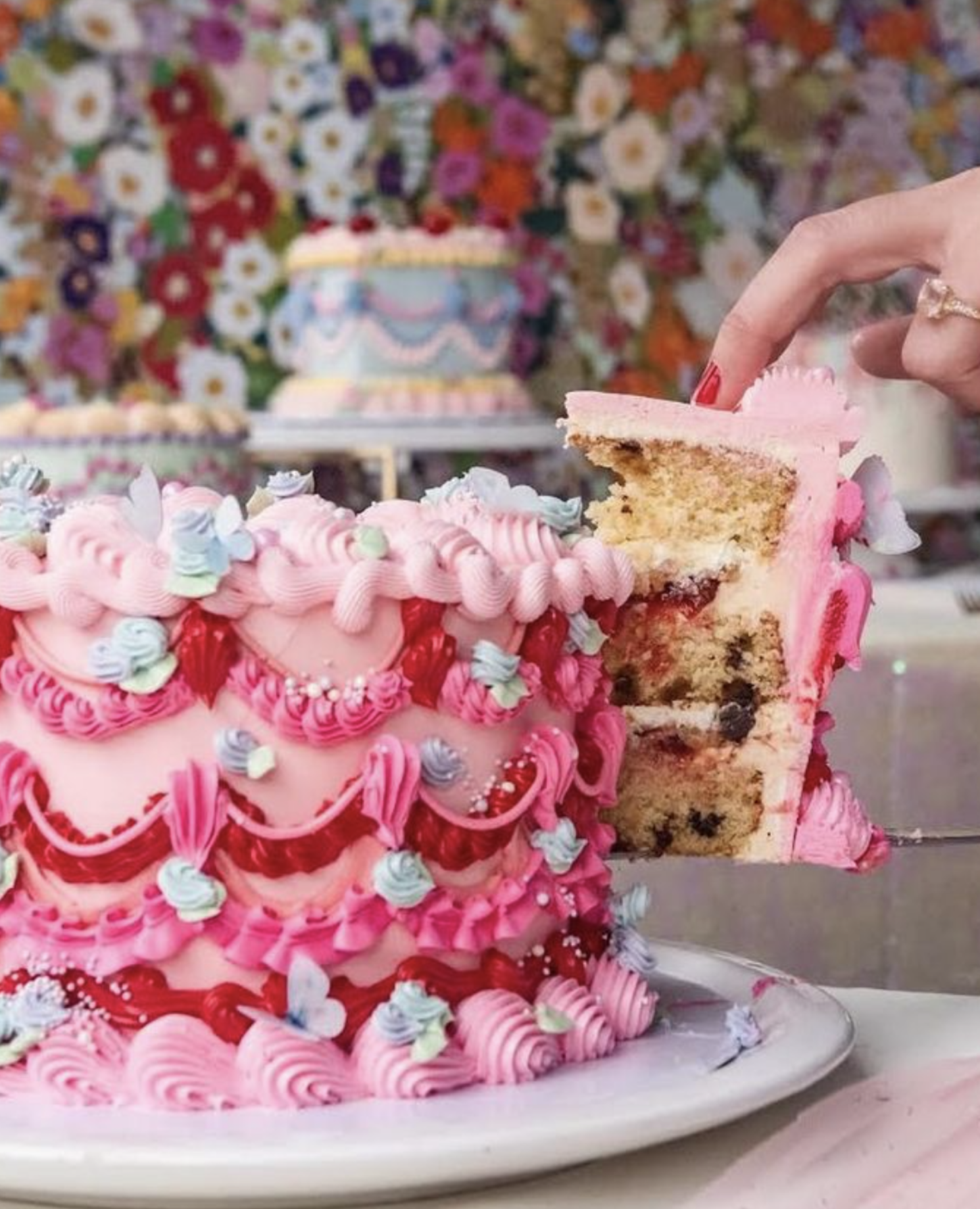 A colorful sheet cake being sliced and served on a plate.