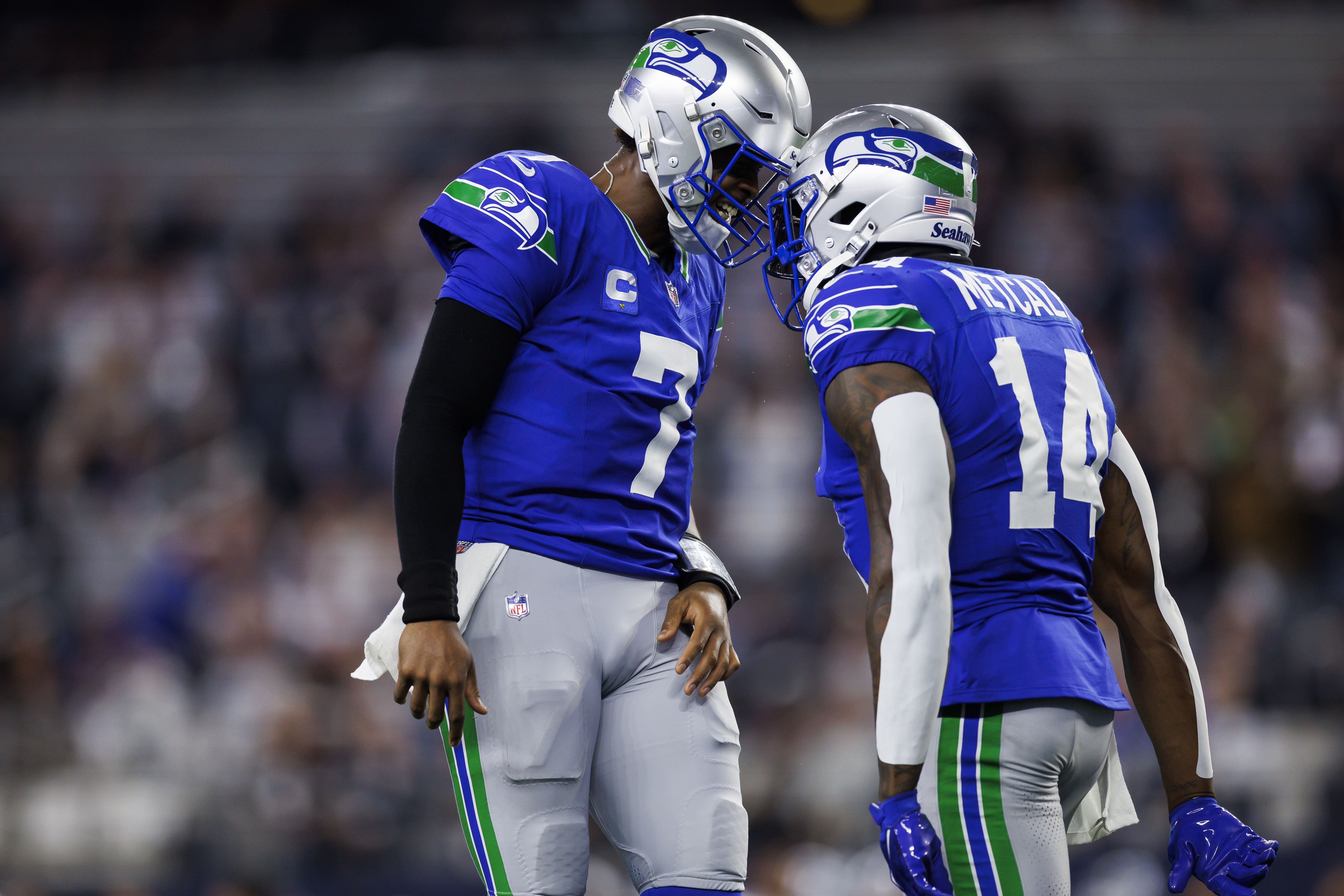 Two men in Seattle Seahawks uniforms celebrate.