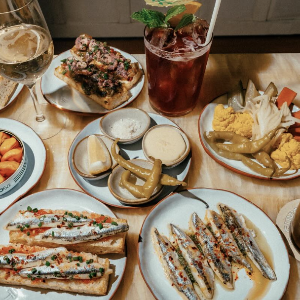 A spread of bar food with a cocktail.