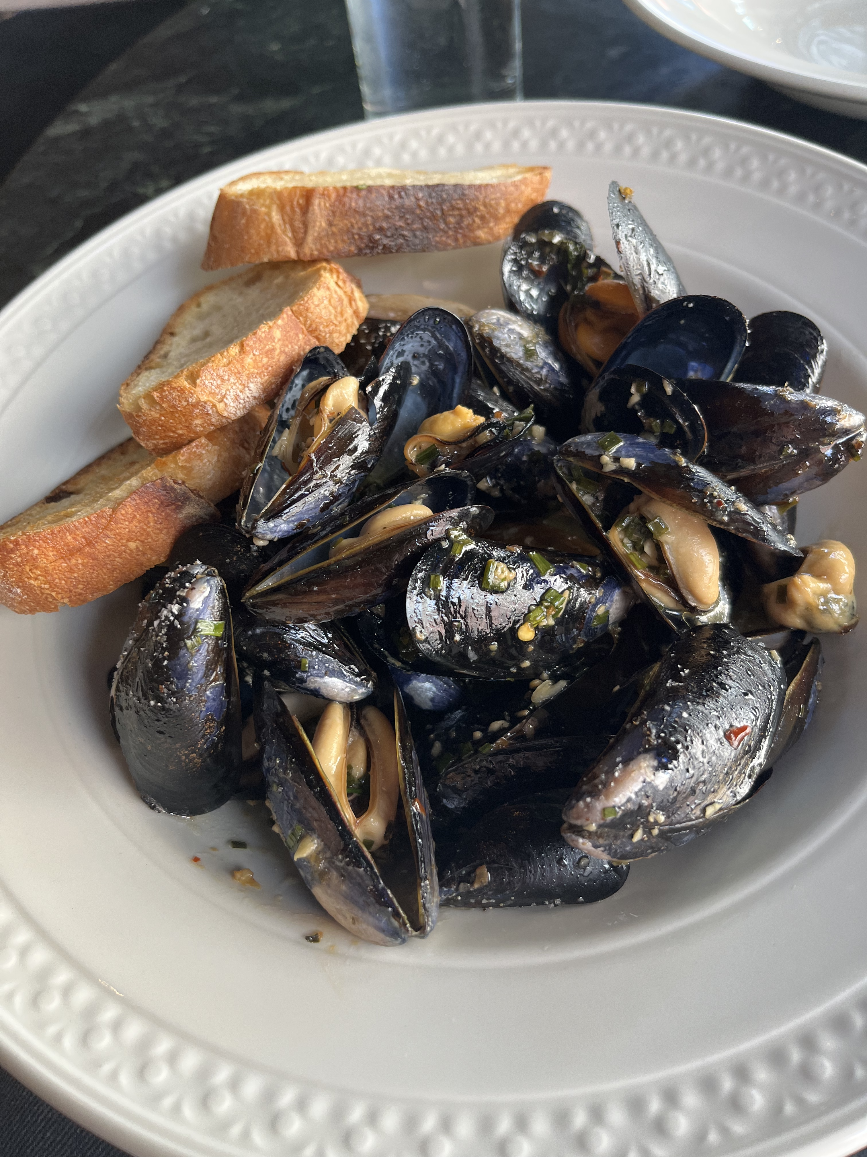 A plate of steamed mussels and bread.