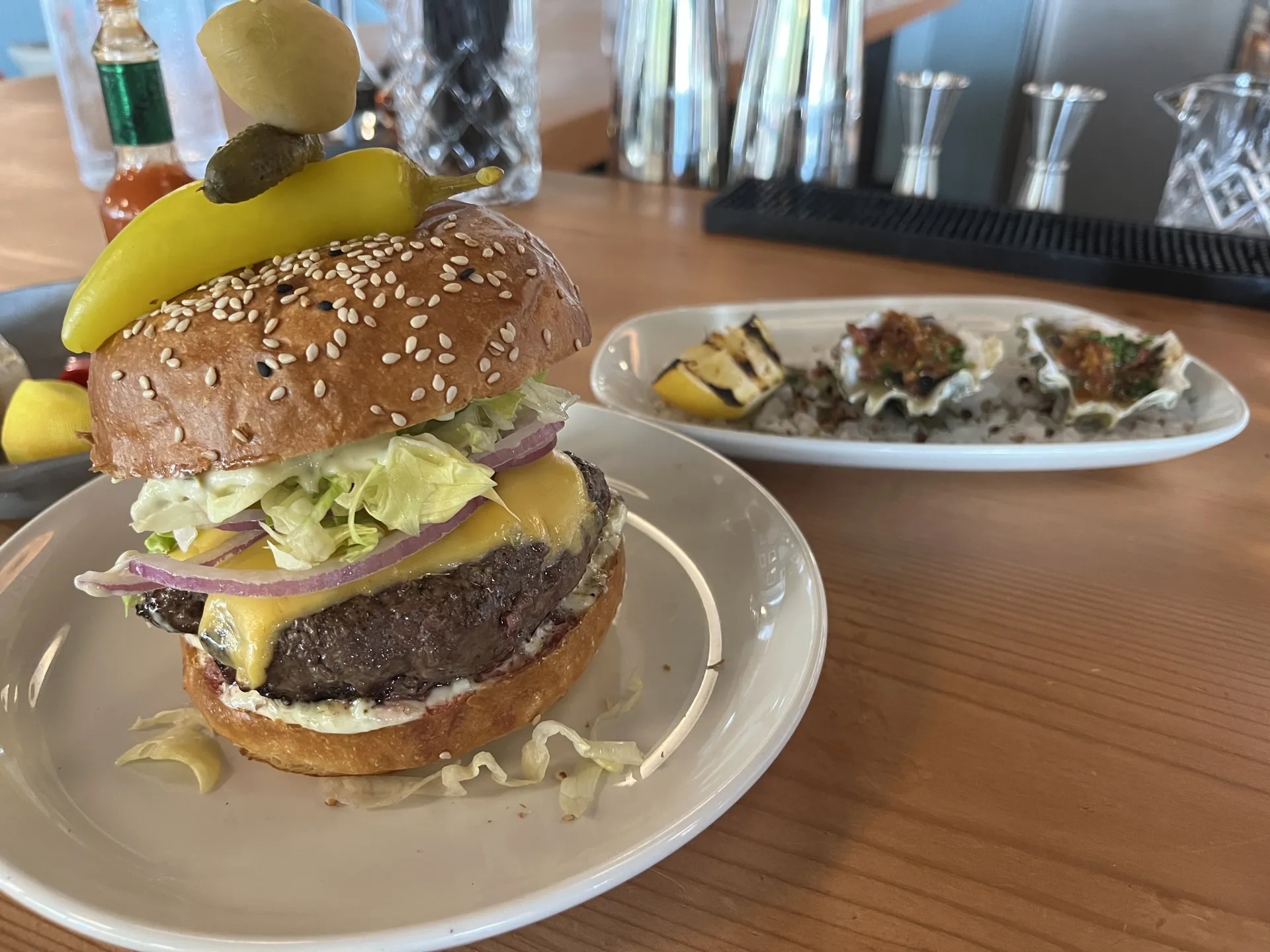 A burger next to a plate of oysters.