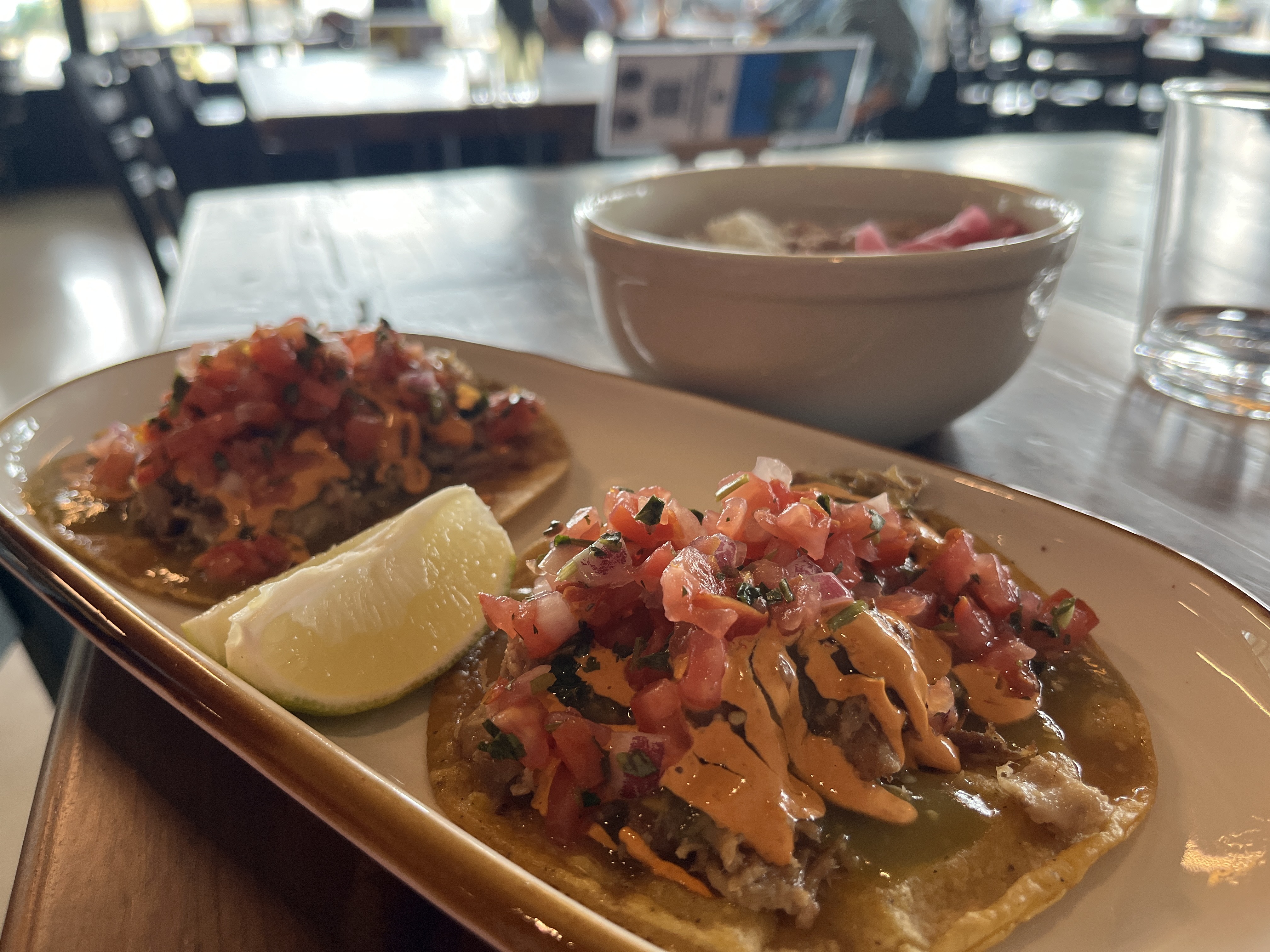 A plate of tacos garnished with a lime.