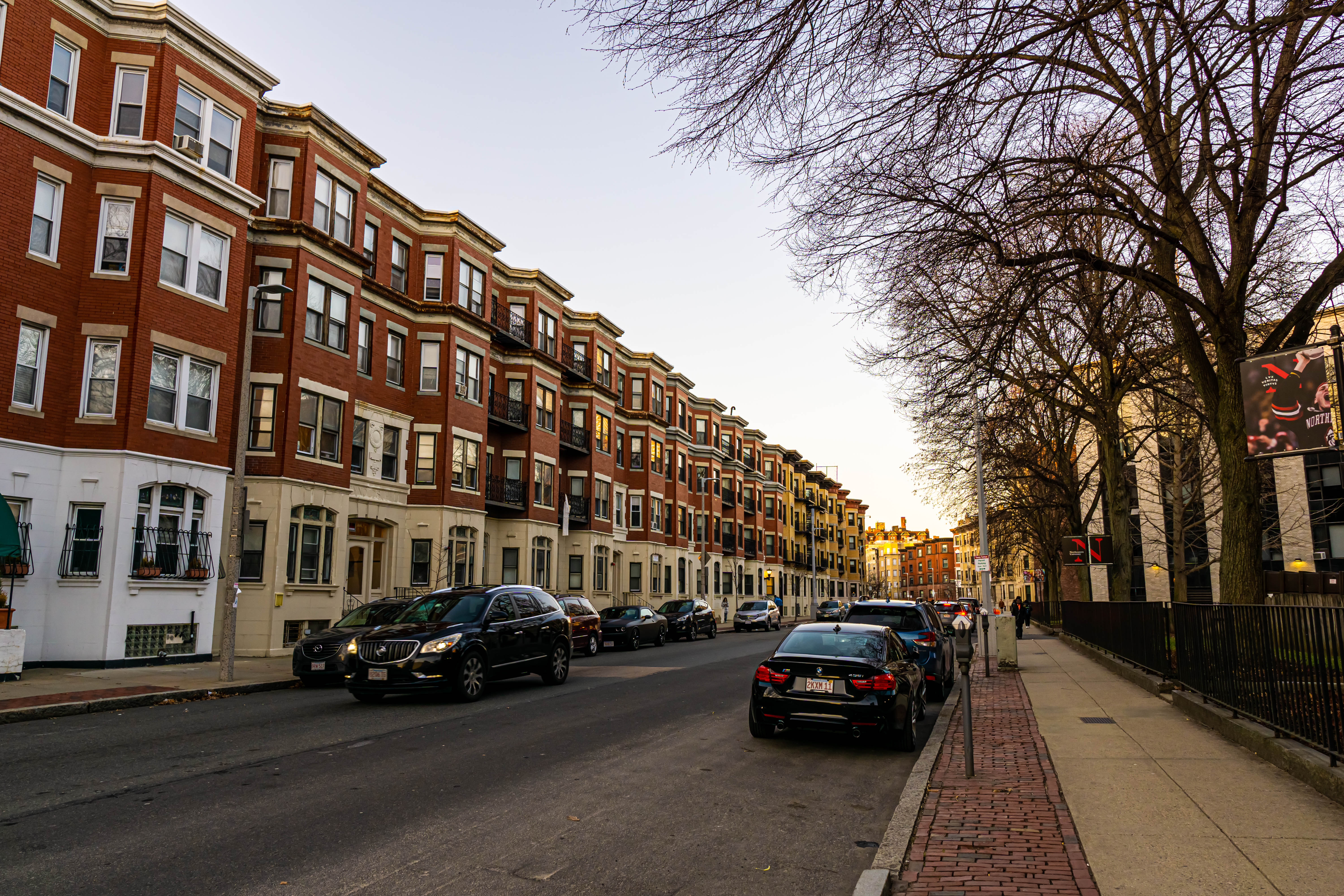 A row of four-story brick buildings along a city street.