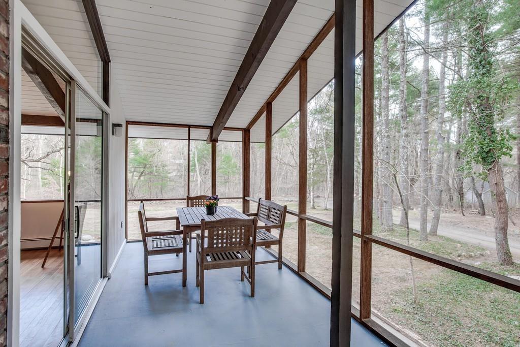 A long, airy, rectangular sunroom off a house.