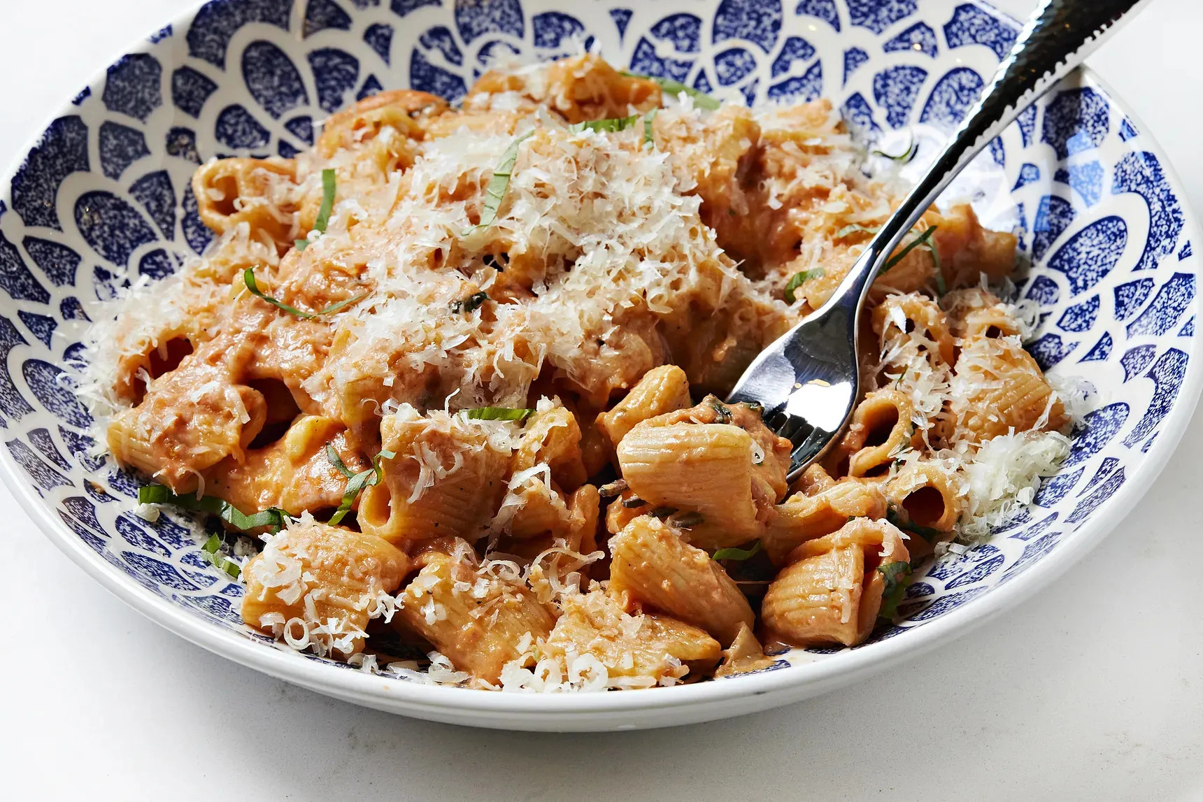 Rigatoni on a blue and white plate.