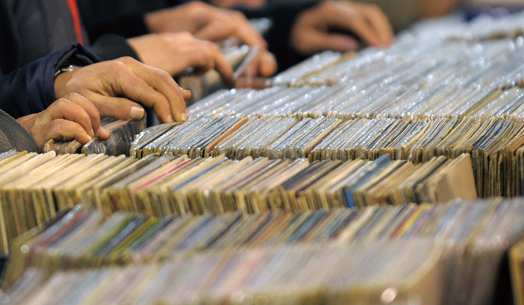 Buyers search for a record in a stand at