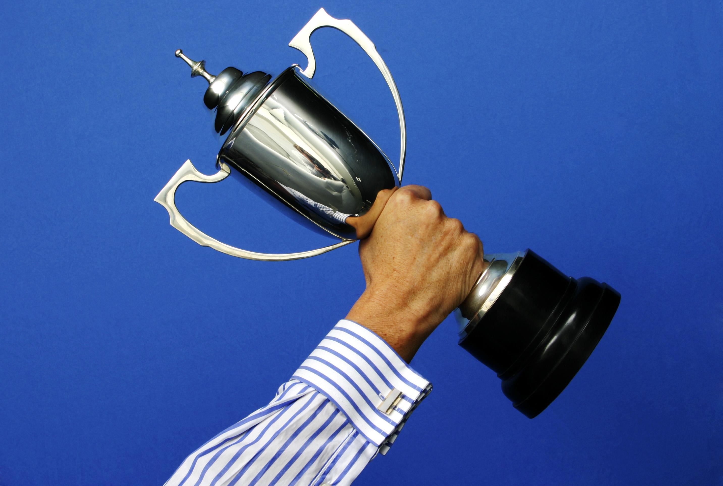 A businessman holding a trophy high in the air on 8 July 2005. AFR GENERIC Pict