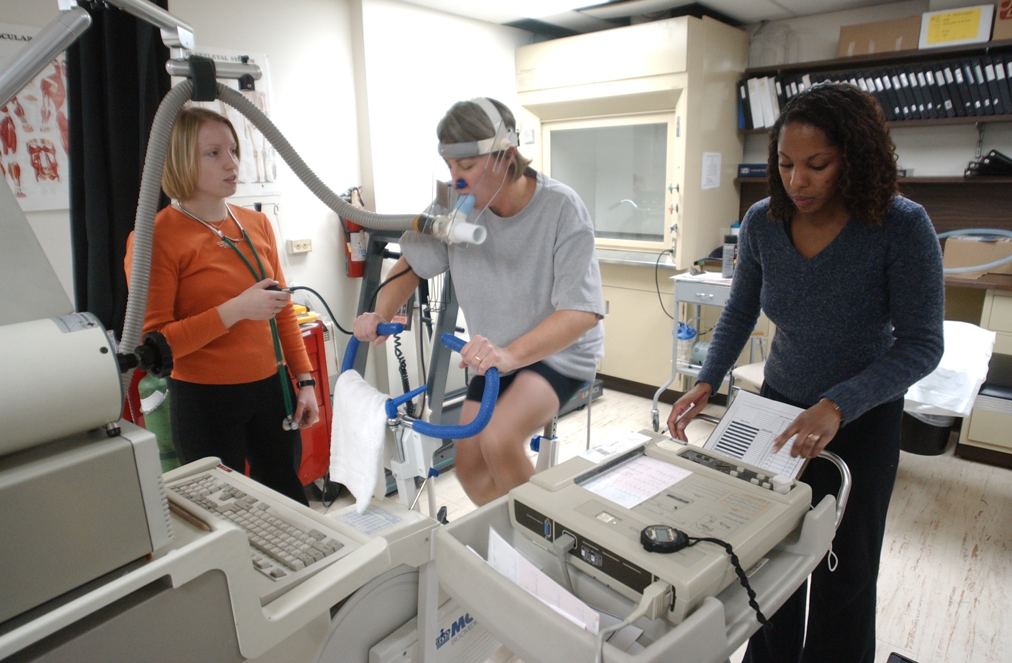 Laura Watt on an exercise bike, undergoes a VO2 Max test with Gerit Dieter (right) and Stephanie Ward right).