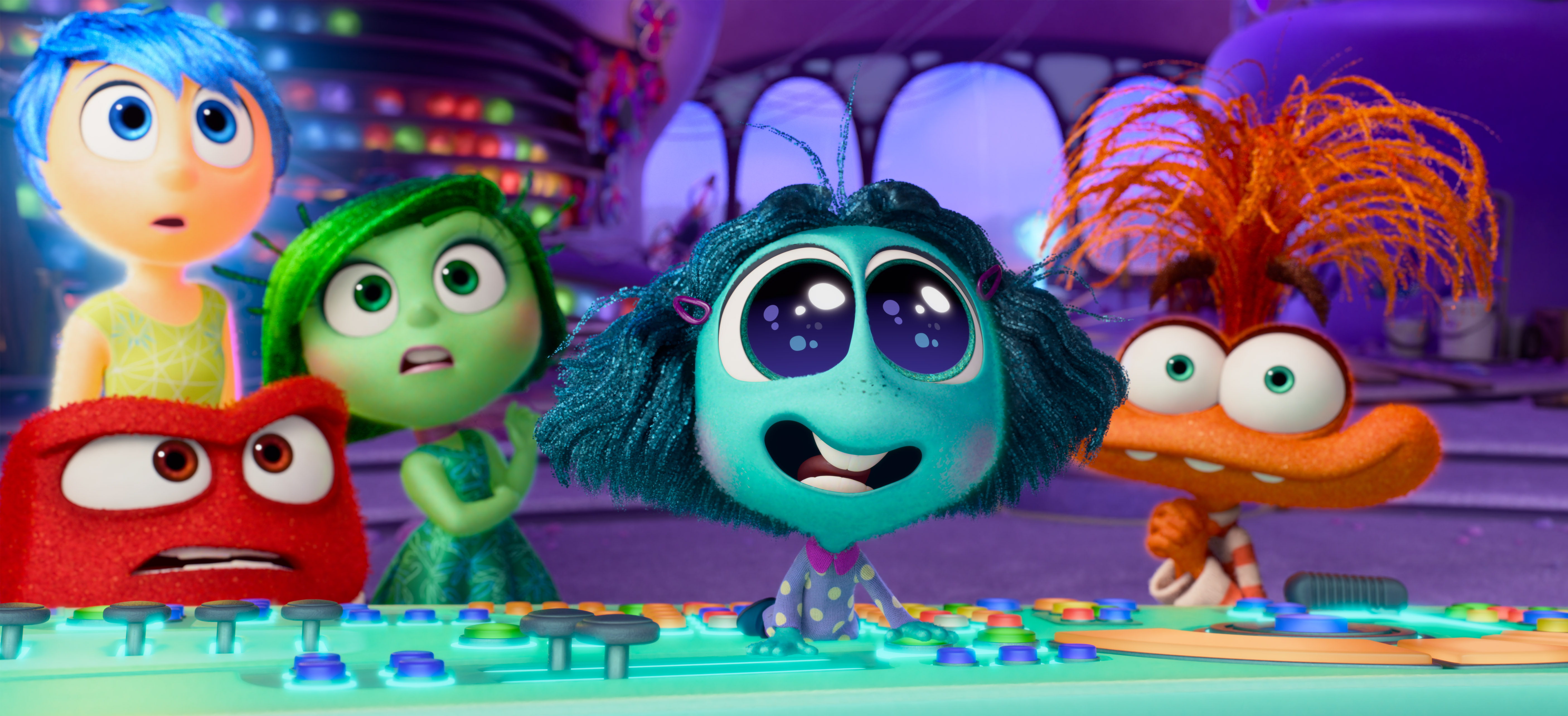 A new emotion, the aquamarine-skinned Envy (Ayo Edebiri), takes the console in Riley’s head and responds to something off screen with huge eyes and a beaming smile in Pixar Animation Studios’ Inside Out 2