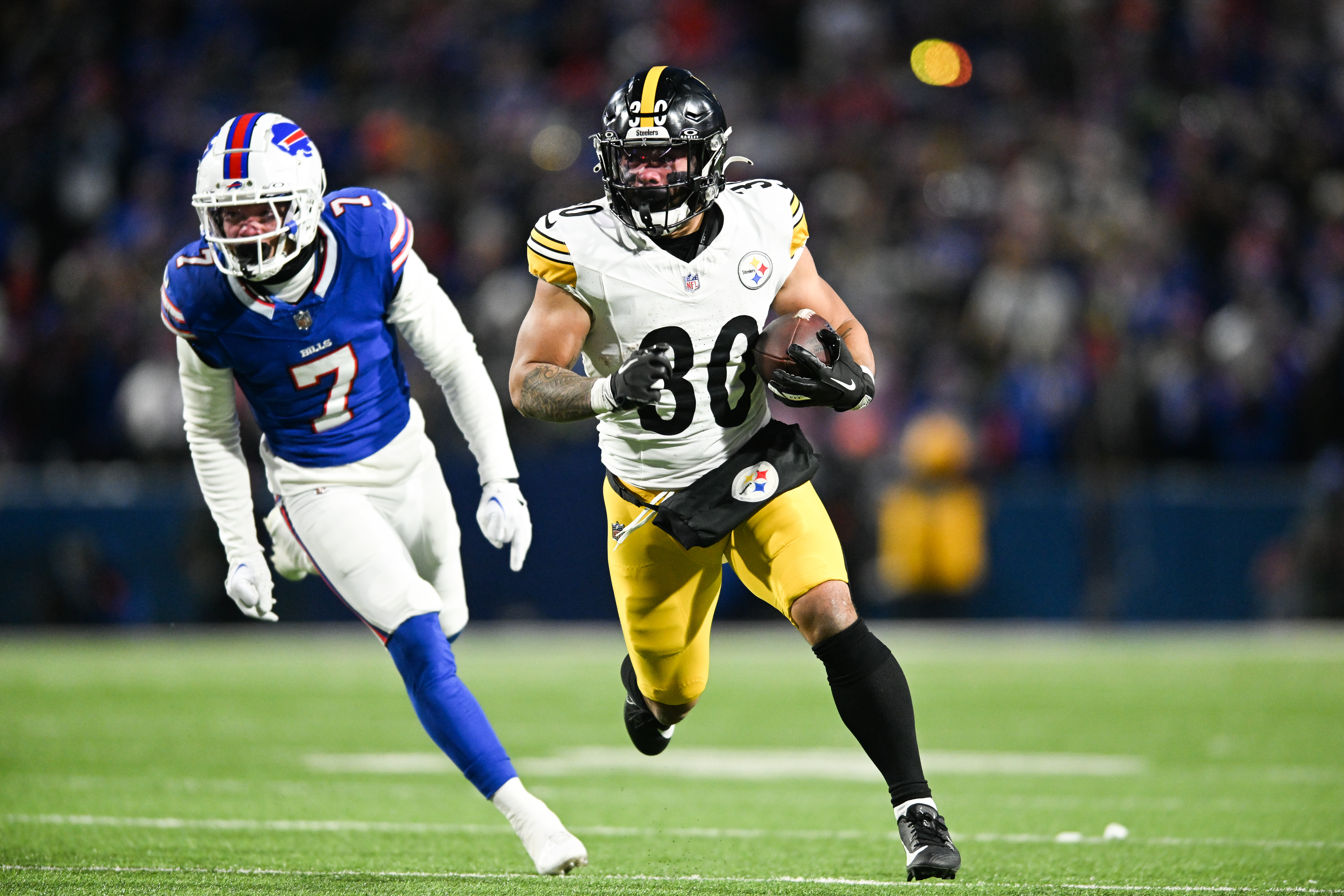 Jaylen Warren #30 of the Pittsburgh Steelers runs with the football during the first half of the NFL wild-card playoff football game against the Buffalo Bills at Highmark Stadium on January 15, 2024 in Orchard Park, New York.