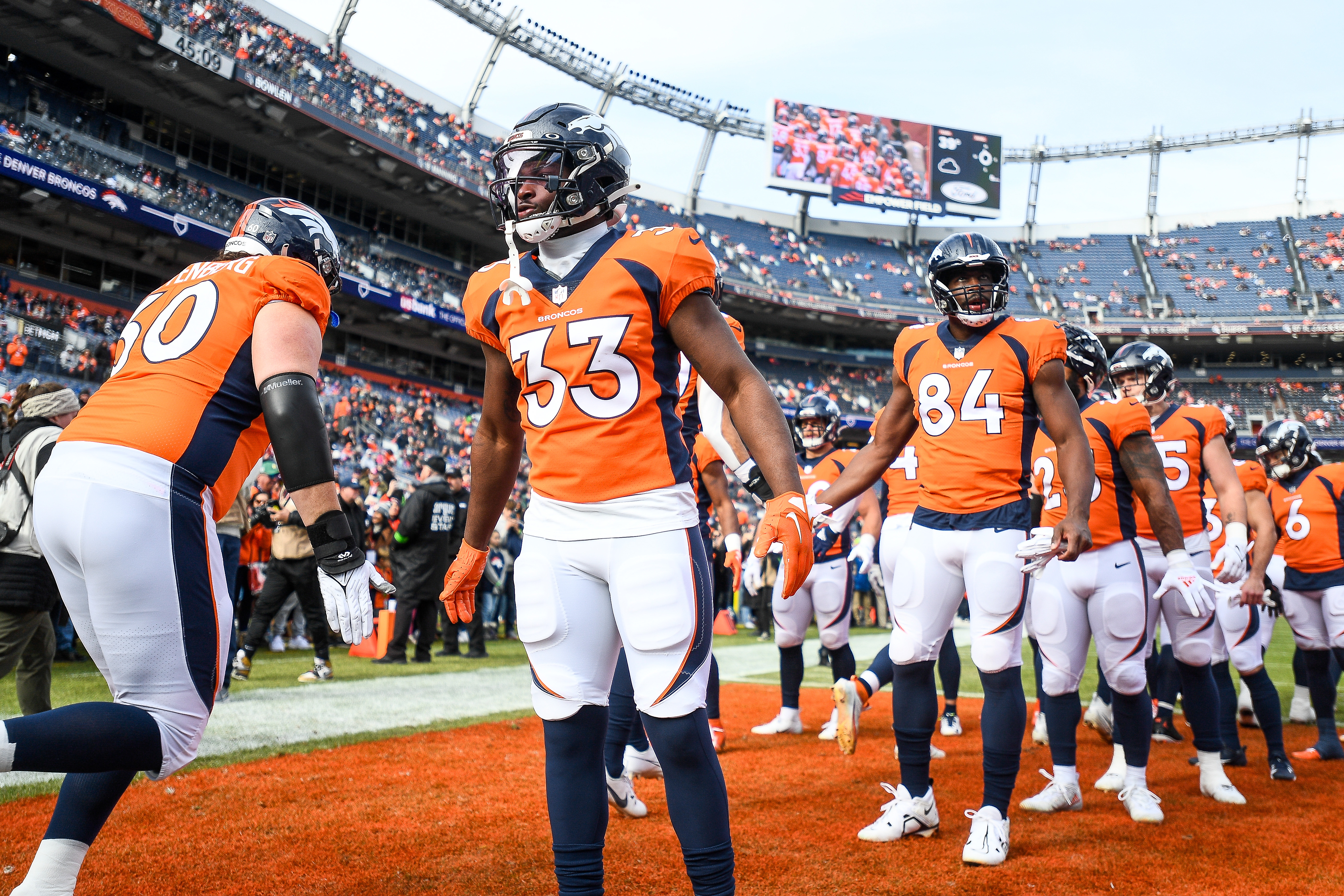 Running back Javonte Williams #33 of the Denver Broncos welcomes players onto the field to warm up before a game against the Los Angeles Chargers at Empower Field at Mile High on December 31, 2023 in Denver, Colorado.