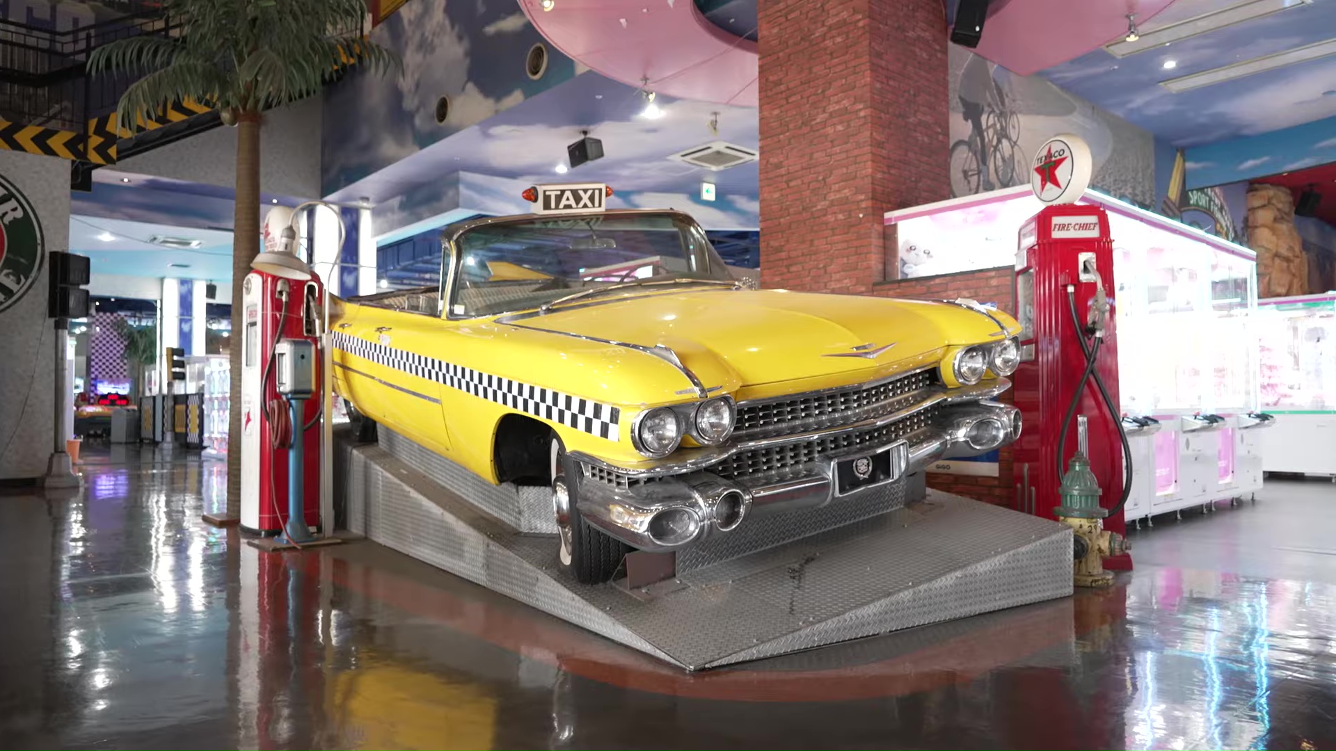 A real 1960s Cadillac done up in taxicab yellow, like in Crazy Taxi, is pictured in a Sega display