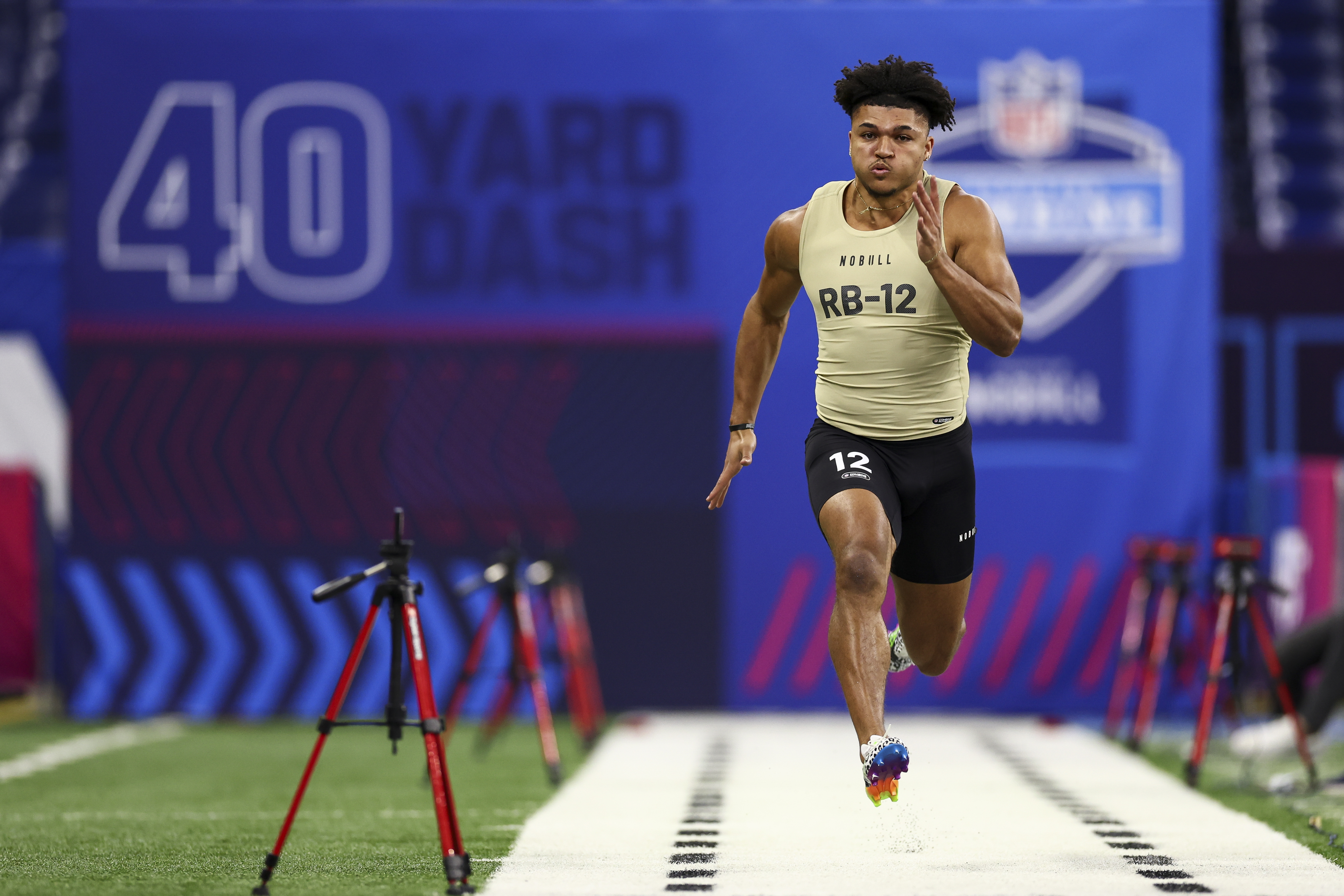 Isaac Guerendo #RB12 of Louisville runs the 40-yard dash during the NFL Combine at the Lucas Oil Stadium on March 2, 2024 in Indianapolis, Indiana.