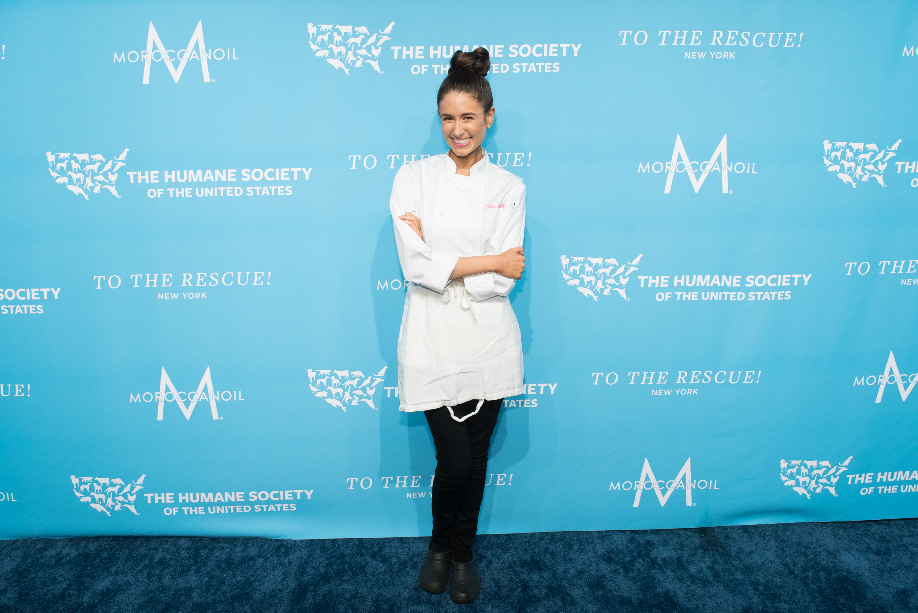 Chef Chloe Coscarelli poses for a photo against a blue backdrop.