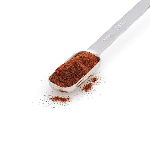 Espresso powder in a stainless steel measuring spoon.