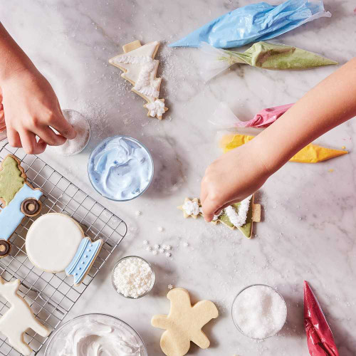 Hands decorating cookies using Natural Food Colors Set