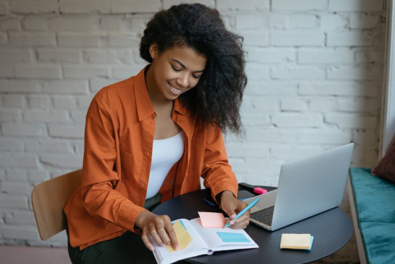 Mujer trabajando en su computadora, sonriendo, siendo productiva