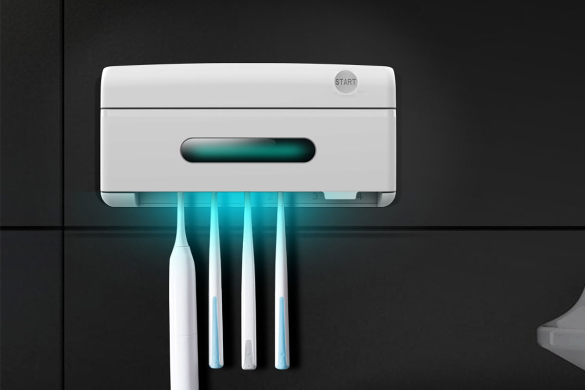 A wall-mounted UV sanitizer for toothbrushes, with four toothbrushes inside