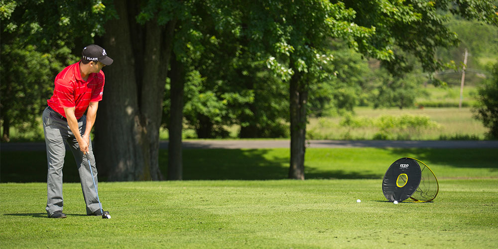 A person using a golf chipping net.