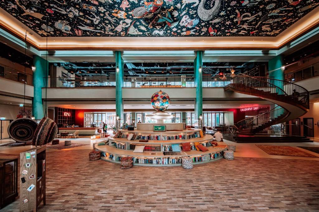 a lobby of a building with a spiral staircase at 25hours Hotel Dubai One Central in Dubai