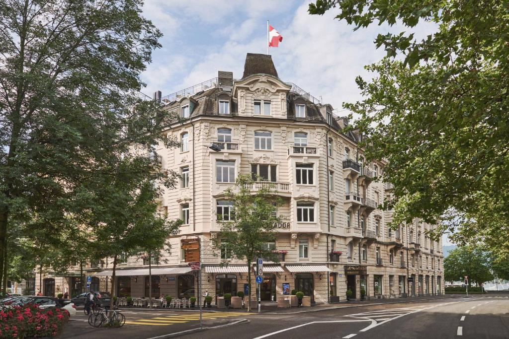 un grande edificio bianco con una bandiera canadese sopra di Small Luxury Hotel Ambassador Zurich a Zurigo