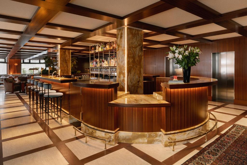 a lobby of a hotel with a bar and stools at Hôtel Des Grands Voyageurs in Paris