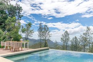 a house with a swimming pool and a table and chairs at Goatfell - Nuwara Eliya in Kandapola