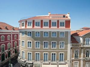 ein hohes Gebäude mit rotem Dach in der Unterkunft Teatro Boutique Rooms & Suites in Lissabon