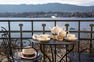 a table with cups and teapots on a balcony at La Réserve Eden au Lac Zurich in Zurich