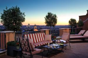 a patio with chairs and a table on a balcony at Rocco Forte Hotel De La Ville in Rome
