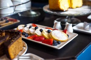 a plate of food with fruit on a table at The Fifteen Keys Hotel in Rome