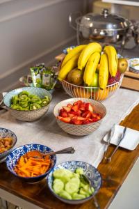 a table topped with bowls of fruit and vegetables at The Fifteen Keys Hotel in Rome