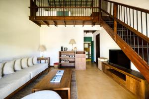 a living room with a couch and a staircase at Kayaam House in Tangalle