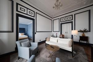 a living room with a white couch and a chair at Torel Palace Lisbon in Lisbon