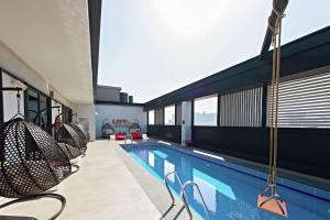 a swimming pool with chairs in a building at Hampton by Hilton Dubai Al Seef in Dubai