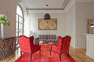 a living room with two red chairs and a couch at The Fifteen Keys Hotel in Rome