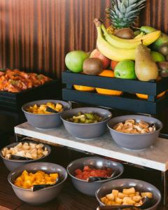a display of different types of fruits and vegetables in bowls at Hôtel Des Grands Voyageurs in Paris