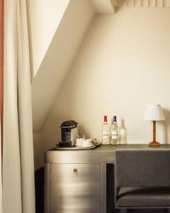 a room with a table with a lamp and a curtain at Hôtel Des Grands Voyageurs in Paris